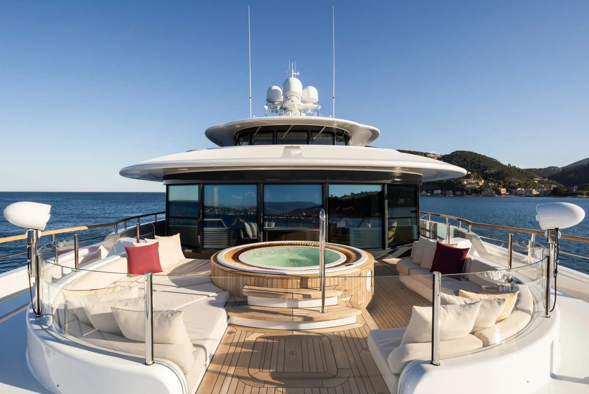 The sun deck of the yacht Synthesis, with a spa pool and lounges facing the sea